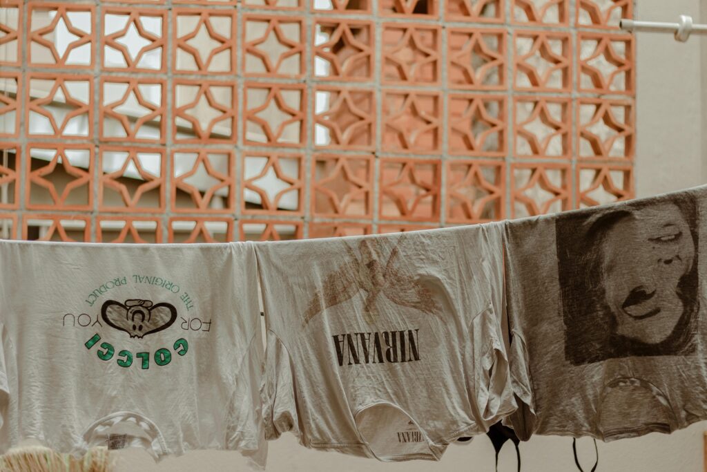 Laundry drying on a clothesline outdoors against a textured wall, representing natural laundry habits.