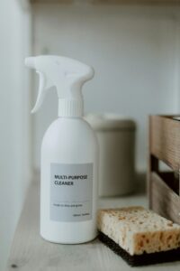 White multi-purpose cleaner spray bottle with a sponge, representing eco-friendly household cleaning products.
